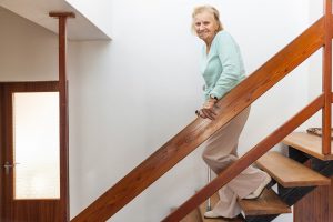 starsza kobieta przy balustradzie zabezpieczającej schody